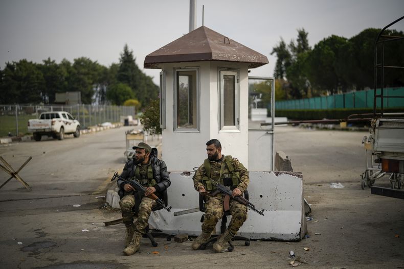 Combatientes sirios custodian la entrada al aeropuerto civil de Lakatia, en la localidad de Hmeimim, en Siria, el 16 de diciembre de 2024.(AP Foto/Leo Correa)