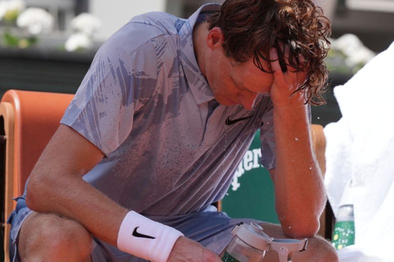 Jannik Sinner, de Italia, reacciona mientras se refresca con agua durante un descanso en el partido de segunda ronda de individuales masculinos contra Juan Manuel Cerúndolo, de Argentina, en el torneo de tenis de Roland Garros en París, el jueves 28 de mayo de 2026, mientras la temperatura sube hasta los 33 °C (91 °F). (Foto AP/Thibault Camus)
