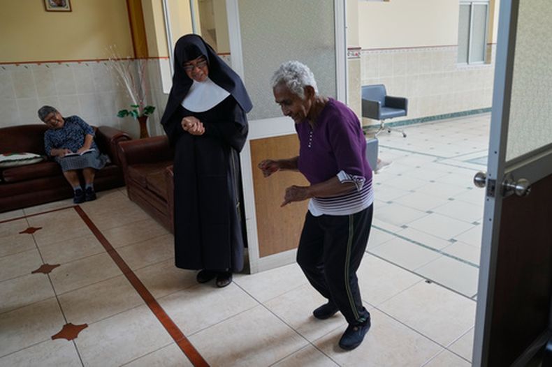 La hermana Sor María Pope observa a una residente de un hogar de ancianos practicar su rutina de baile en preparación para la próxima visita del papa León XIV —prevista para noviembre— a ese centro gestionado por una congregación en el Callao, Perú, el viernes 25 de septiembre de 2026. (AP Foto/Martín Mejía)