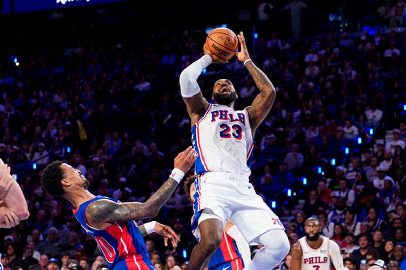LeBron James (23) de los 76ers de Filadelfia dispara el aro ante John Collins de los Pistons de Detroit, el domingo 25 de octubre de 2026, en Filadelfia. (AP Foto/Chris Szagola)