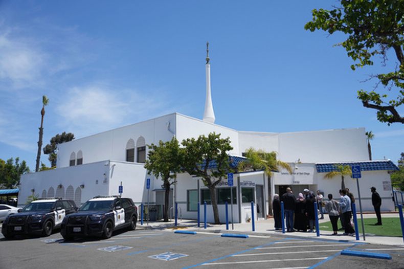 ARCHIVO - Personas se reúnen mientras vehículos policiales permanecen estacionados frente al Centro Islámico de San Diego, el día después de un tiroteo, el 19 de mayo de 2026, en San Diego. (Foto AP/Jae C. Hong, archivo)