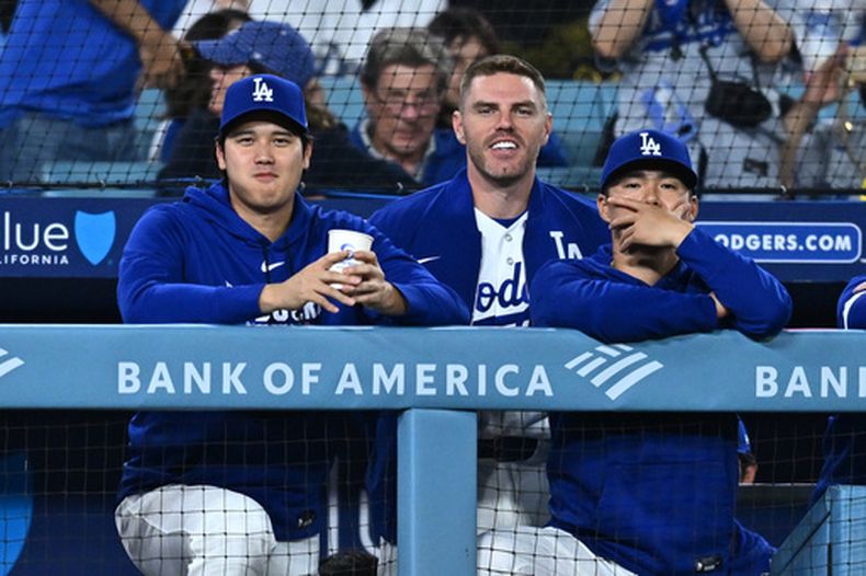 Shohei Ohtani, izquierda, de los Dodgers de Los Ángeles, observa desde la caseta en la novena entrada del juego de béisbol de Grandes Ligas frente a los Nacionales de Washington, el viernes 4 de septiembre de 2026, en Los Ángeles. (AP Foto/William Liang)