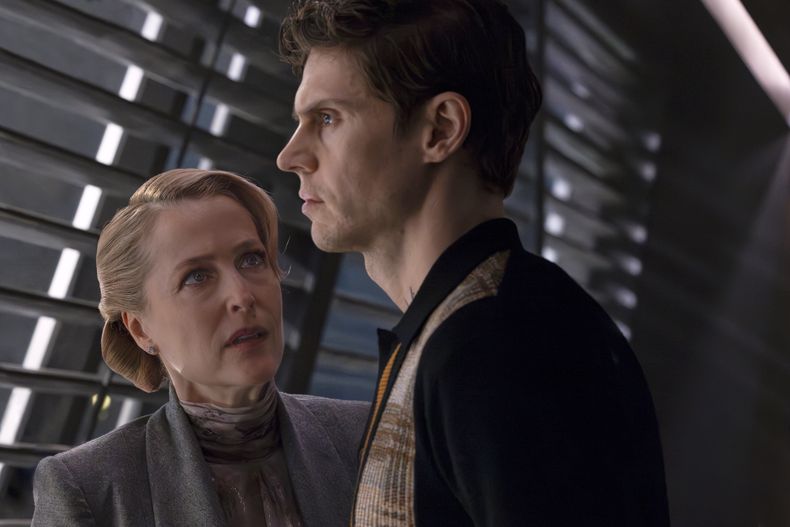 Esta imagen publicada por Disney muestra a Gillian Anderson, a la izquierda, y Evan Peters en una escena de Tron: Ares. (Disney via AP)