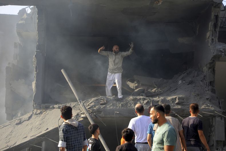 Palestinos buscan sobrevivientes entre los restos de edificios destruidos por ataques aéreos israelíes contra el campo de refugiados de Jabaliya, a las afueras de la Ciudad de Gaza, el 31 de octubre de 2023 (AP Foto/Abdul Qader Sabbah)