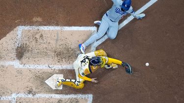 Teoscar Hernández de los Dodgers de Los Ángeles es sacado out en el plato por el receptor William Contreras de los Cerveceros de Milwaukee en el primer juego de la Serie de Campeonato de la Liga Nacional, el lunes 13 de octubre de 2025, en Milwaukee. (AP Foto/Morry Gash)