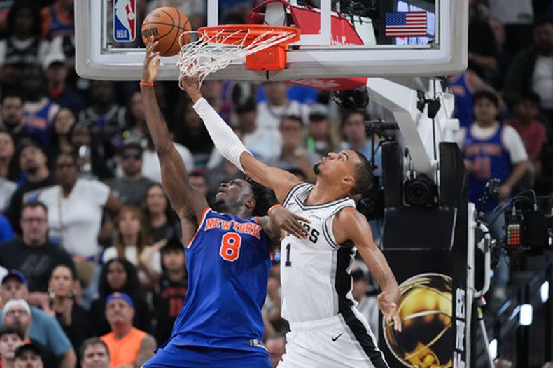 El alero de los Spurs de San Antonio Victor Wembanyama defiende al alero de los Knicks de Nueva York OG Anunoby mientras salta para anotar en el juego 2 de las Finales de la NBA el viernes 5 de junio del 2026. (AP Foto/Eric Gay)
