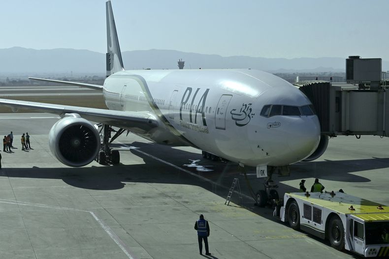 ARCHIVO – Personal de tierra trabaja junto a un avión de la aerolínea nacional Pakistan International Airlines que se prepara para despegar de París, después de que la empresa resumiera los vuelos directos a Europa, después de que la Unión Europea levantara una prohibición de cuatro años, en el Aeropuerto Internacional de Islamabad, en Islamabad, Pakistán, el 10 de enero de 2025. (AP Foto), Archivo)