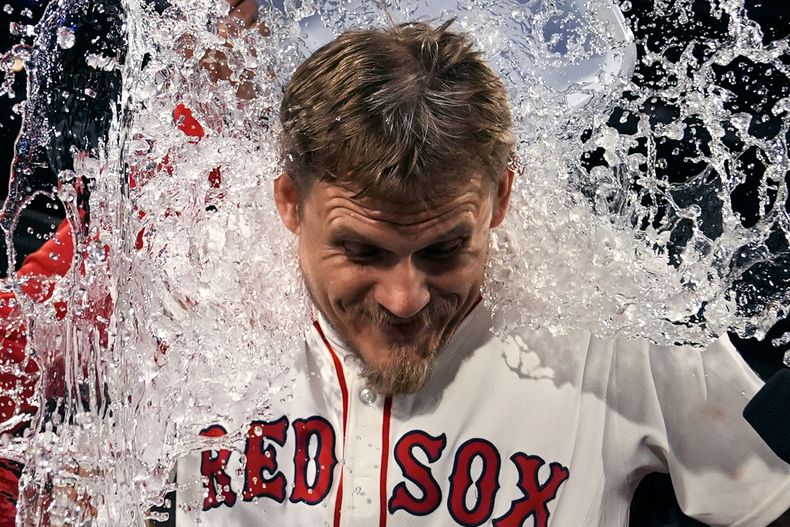 Tanner Houck, de los Medias Rojas de Boston, es empapado con la hielera en el festejo tras su juego completo con blanqueada ante los Guardianes de Cleveland, el miércoles 17 de abril de 2024 (AP Foto/Charles Krupa)