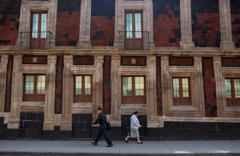 ARCHIVO – Varios peatones caminan frente a un edificio histórico ligeramente inclinado en el centro de Ciudad de México, el 15 de junio de 2016. La ciudad fue construida sobre el lecho de un lago desecado, y muchas construcciones están notablemente inclinadas debido a que se han hundido de forma irregular sobre la tierra blanda durante décadas o siglos. (AP Foto/Rebecca Blackwell, Archivo)