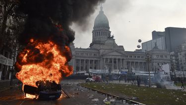 Un automóvil arde durante enfrentamientos entre la policía y manifestantes antigubernamentales frente al Congreso, donde los senadores debaten proyectos de ley promovidos por el presidente argentino Javier Milei en Buenos Aires, Argentina, el miércoles 12 de junio de 2024. (AP Foto/Gustavo Garello)