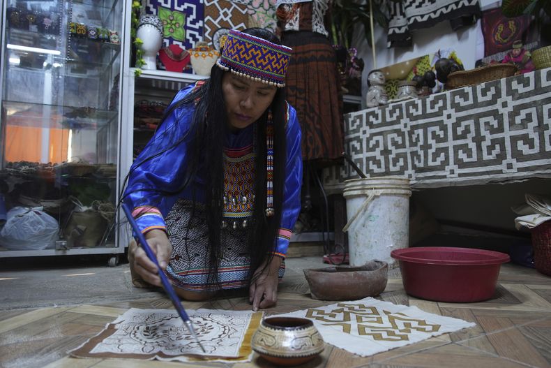 Sadith Silvano, de los Paoyhan, una comunidad indígena Shipibo-Konibo en la Amazonía, pinta en su casa en Lima, Perú, el 19 de octubre del 2024. (Foto AP/Guadalupe Pardo)