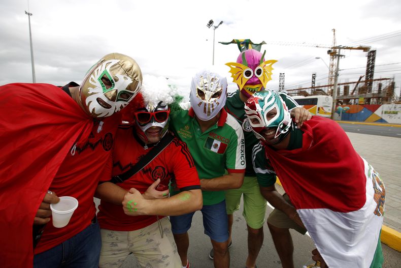 Hinchas de M&eacute;xico con m&aacute;scaras de luchadores posan antes de un partido contra Brasil en el Mundial el martes, 17 de junio de 2014, en Fortaleza, Brasil. (AP Photo/Eduardo Verdugo)