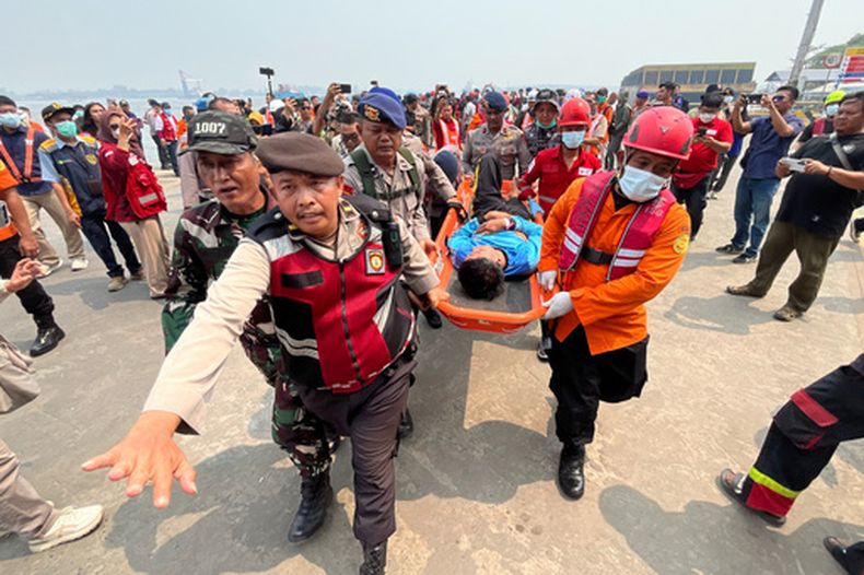En la imagen, tomada con un teléfono inteligente, rescatistas trasladan en camilla a un sobreviviente de un ferry de pasajeros que volcó debido al mal tiempo en el mar de Java, en un puerto en Banjarmasin, Kalimantan del Sur, Indonesia, el martes 15 de septiembre de 2026. (AP Foto/Iman Satria)