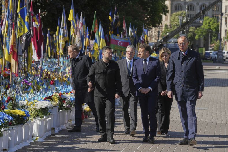 De izquierda a derecha, el primer ministro de Polonia, Donald Tusk; el presidente de Ucrania, Volodymyr Zelenskyy; el primer ministro de Reino Unido, Keir Starmer; el presidente de Francia, Emmanuel Macron, y el canciller de Alemania, Friedrich Merz, llegan al memorial a los soldados ucranianos caídos para depositar flores, en la Plaza de la Independencia de Kiev, Ucrania, el 10 de mayo de 2025. (AP Foto/Evgeniy Maloletka)