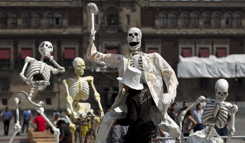Un hombre transporta la representaci&oacute;n de un esqueleto en preparaci&oacute;n para una ofrenda por el D&iacute;a de Muertos en el Z&oacute;calo de la Ciudad de M&eacute;xico, el martes 29 de octubre de 2013. Los mexicanos celebran el D&iacute;a de M