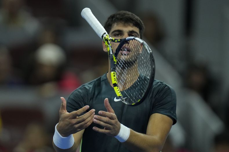 Carlos Alcaraz suelta su raqueta durante el partido contra Jannik Sinner en las semifinales del Abierto de China, el martes 3 de octubre de 2023, en Beijing. (AP Foto/Andy Wong)