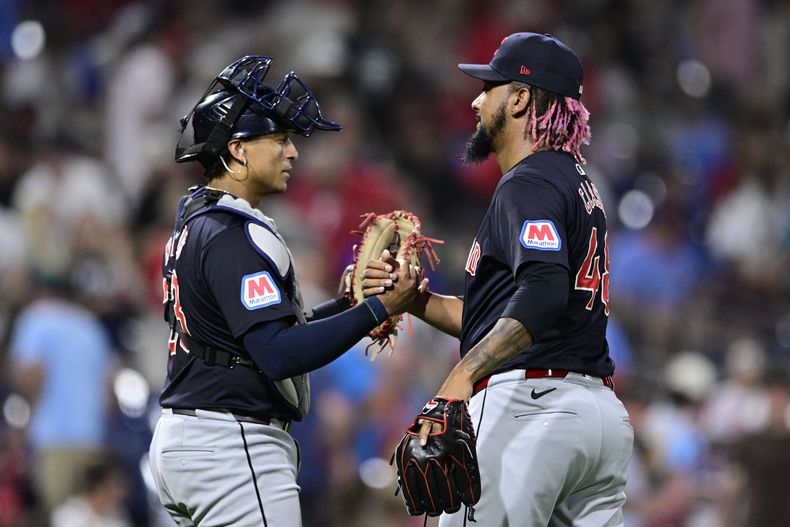 El dominicano Emmanuel Clase (derecha) y Bo Naylor festejan la victoria de los Guardianes de Cleveland sobre los Filis de Filadelfia, el viernes 26 de julio de 2024. (AP Roto/Derik Hamilton)