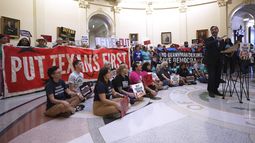 El legislador Joaquin Castro, derecha, habla con manifestantes reunidos en la rotonda frente a la Cámara de Representantes en el Capitolio de Texas, en un momento en que los legisladores debaten la reconfiguración del mapa parlamentario de Estados Unidos, el miércoles 20 de agosto de 2025, en Austin, Texas. (AP Foto/Eric Gay)