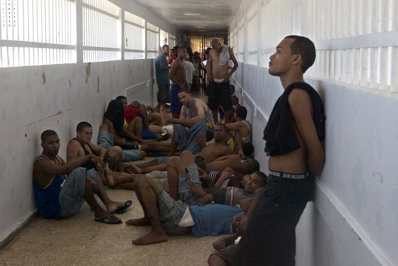 ARCHIVOS - Presos de pie en un pasillo durante el tiempo en el que se les permite salir de la celda en la cárcel Najayo, en San Cristobal, al oeste de Santo Domingo, el 30 de mayo de 2007. (AP Foto/Ramón Espinosa, Archivo)