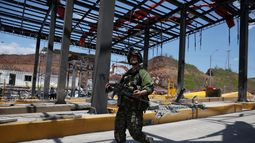 Un soldado camina por una estación de peaje de la Carretera Panamericana, dañada por la explosión de un coche bomba que el ejército atribuyó a grupos disidentes de las FARC, el sábado 8 de agosto de 2026, en Santander de Quilichao, Colombia. (AP Foto/Santiago Saldarriaga)