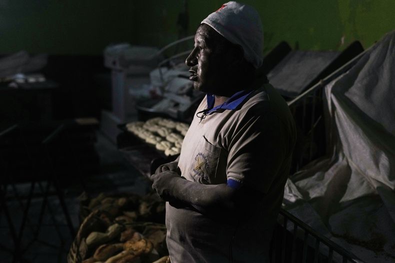 El panadero Juan de Dios Castillo da una entrevista mientras hornea pan de batalla, elaborado con harina subsidiada por el gobierno, en El Alto, Bolivia, el viernes 8 de agosto de 2025. (AP Foto/Juan Karita)