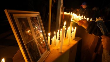 Una persona enciende una vela durante una vigilia frente a la mina de cobre El Teniente, operada por Codelco, donde ocurrió un derrumbe y varias personas fallecieron, el sábado 2 de agosto de 2025, en Rancagua, Chile. (AP Foto/Esteban Félix)