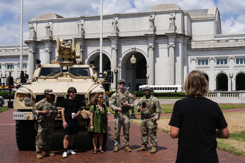 Miembros de la Guardia Nacional del Distrito de Columbia posan para fotografiarse con ciudadanos fuera de la Union Station, el sábado 16 de agosto de 2025, en Washington. (AP Foto/Julia Demaree Nikhinson)
