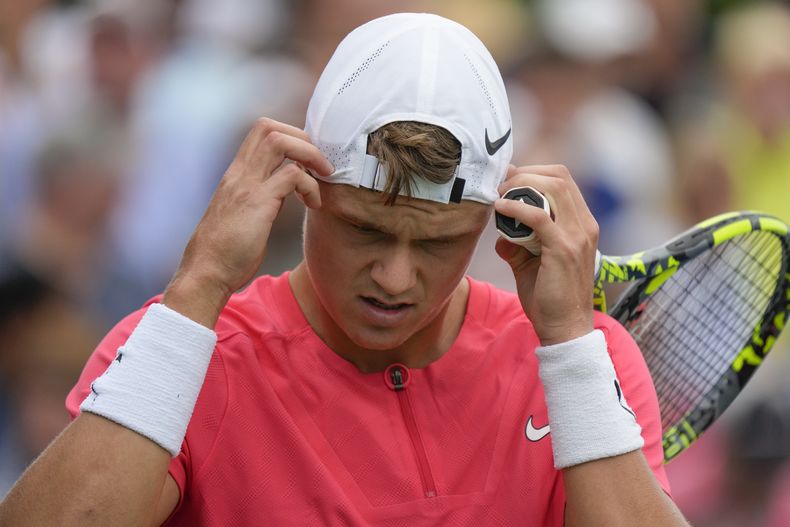 El danés Holger Rune se ajusta el gorro durante el partido contra el español Roberto Carballés Baena en la primera ronda del US Open, el lunes 28 de agosto de 2023. (AP Foto/John Minchillo)