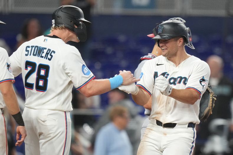 Jakob Marsee (derecha) es felicitado por Kyl Stowers, su compañero en los Marlins de Miami, luego de batear un jonrón de tres carreras en el juego del sábado 9 de mayo de 2026, ante los Nacionales de Washington (AP Foto/Lynne Sladky)