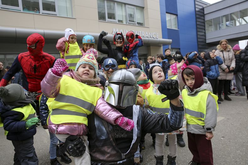 Alpinistas de Kosovo disfrazados de superhéroes entregan regalos a niños en un hospital en Pristina, Kosovo, el viernes 13 de diciembre de 2024. (AP Foto/Visar Kryeziu)