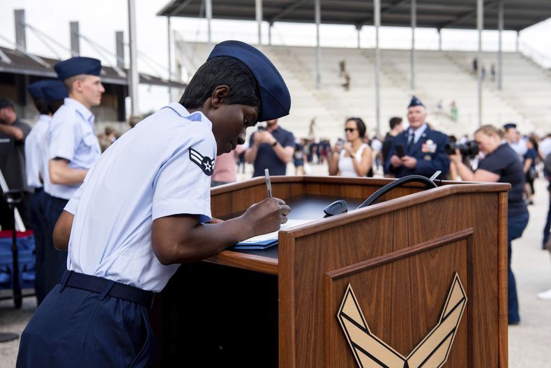 La aviadora de primera clase Delbrah Assamoi, de Costa de Marfil, firma su certificado de ciudadanía estadounidense al final de una ceremonia de entrenamiento militar básico en la Base Conjunta San Antonio-Lackland, el 26 de abril de 2023, en San Antonio, Texas. (Vanessa R. Adame/Fuerza Aérea de Estados Unidos vía AP)
