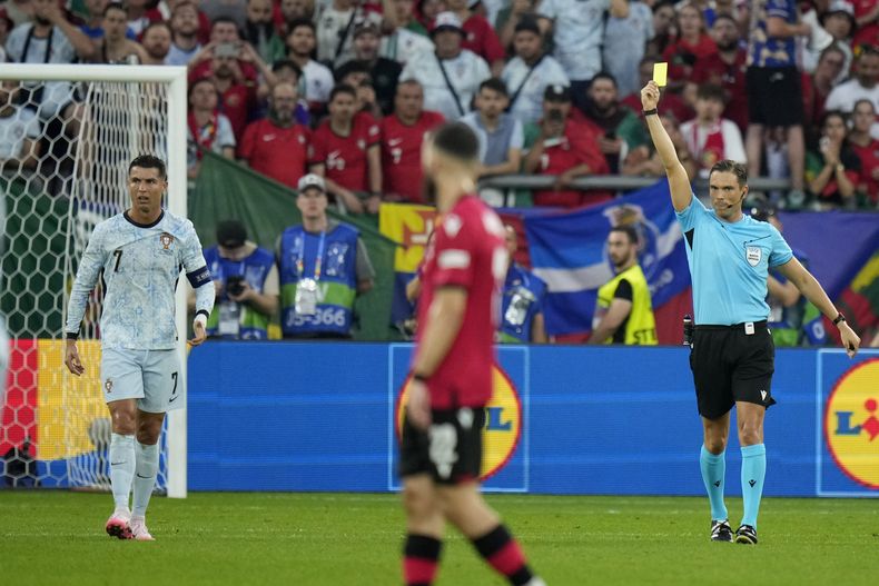 Cristiano Ronaldo, de Portugal, recibe una amonestación del árbitro Sandro Schärer durante el partido del Grupo F entre Georgia y Portugal en la Eurocopa 2024, en Gelsenkirchen, Alemania, el miércoles 26 de junio de 2024. (AP Foto/Alessandra Tarantino)