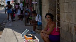 Una mujer carga una batería utilizando un pequeño panel solar en la calle durante un apagón en La Habana, Cuba, el viernes 18 de septiembre de 2026. (Foto AP/Ramón Espinosa)