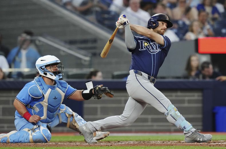 Brandon Lowe, de los Rays de Tampa Bay, conecta un jonrón de dos carreras delante del cátcher mexicano Alejandro Kirk, de los Azulejos de Toronto, el marts 23 de julio de 2024 (Chris Young/The Canadian Press via AP)
