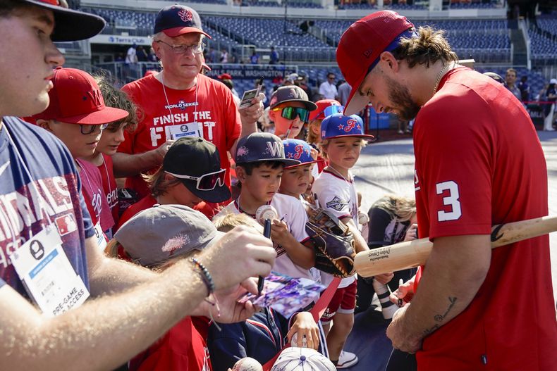 Dylan Crews, de los Nacionales de Washington, la segunda selección global del draft de Grandes Ligas, firma autógrafos antes del juego de béisbol en contra de los Gigantes de San Francisco en Nationals Park, el sábado 22 de julio de 2023, en Washington. (AP Foto/Alex Brandon)