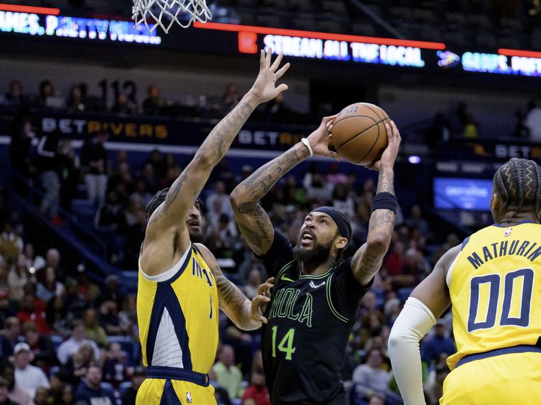 Brandon Ingram, alero de los Pelicans de Nueva Orleáns, dispara frente a Obi Toppin, de los Pacers de Indiana, el viernes 1 de marzo de 2024 (AP Foto/Matthew Hinton)