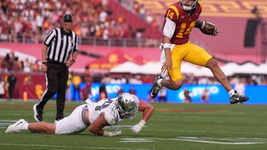 El quarterback de los Trojans de Southern California, Jayden Maiava (derecha), evade al apoyador de los Ducks de Oregon, Teitum Tuioti, durante la primera mitad de un partido de fútbol americano universitario, el 26 de septiembre de 2026, en Los Ángeles. (Foto AP/Mark J. Terrill)