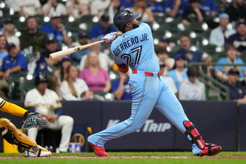 El dominicano Vladimir Guerrero Jr., de los Azulejos de Toronto, batea un doblete en el décimo inning del juego ante los Cerveceros de Milwaukee, el martes 14 de abril de 2026 (AP Foto/Aaron Gash)