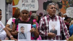 Varias personas que sostienen fotografías de parientes migrantes --de los que dicen fueron detenidos en Estados Unidos y aguardan a ser deportados-- participan en una manifestación organizada por el gobierno en Caracas, Venezuela, el martes 18 de marzo de 2025, para protestar por la deportación de presuntos miembros de la pandilla venezolana Tren de Aragua, que fueron transferidos a una cárcel en El Salvador. (AP Foto/Ariana Cubillos)