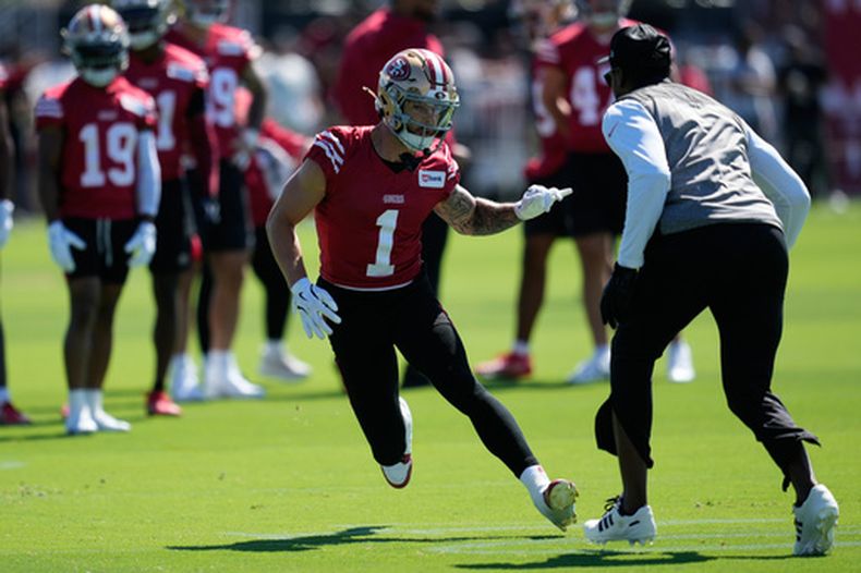 El receptor de los 49ers de San Francisco Ricky Pearsall corre durante un ejercicio con el entrenador de receptores Leonard Hankerson en el campamento de entrenamiento el lunes 27 de julio del 2026. (AP Foto/Jeff Chiu)
