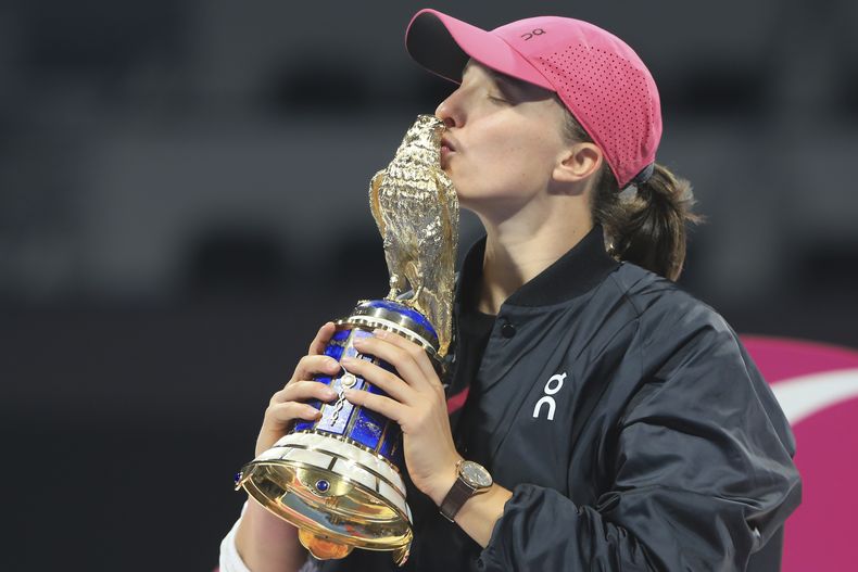 La polaca Iga Swiatek besa el trofeo del Abierto de Qatar, tras vencer a la kazaja Elena Rybakina en la final del sábado 17 de febrero de 2024 (AP Foto/Hussein Sayed)