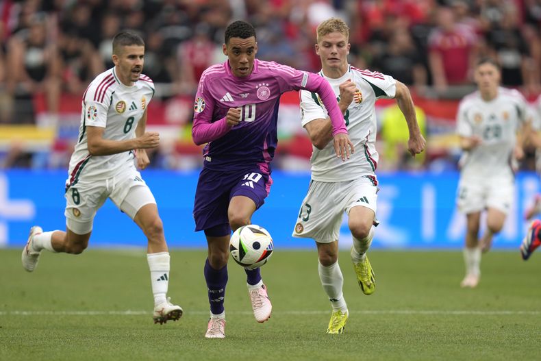 El alemán Jamal Musiala y los húngaros Adam Nagy y Andras Schafer en acciones durante el encuentro del Grupo A de la Euro 2024 el miércoles 19 de junio del 2024. (AP Foto/Ariel Schalit)