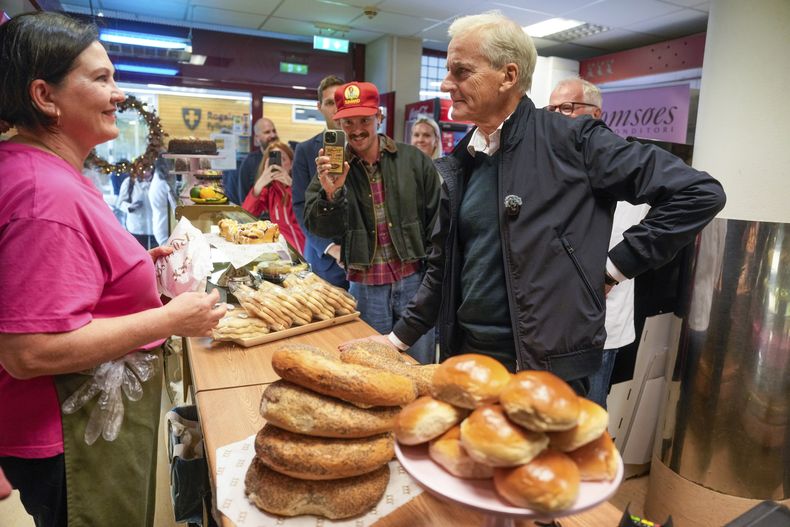 Jonas Gahr Store, a la derecha, presidente del partido Ap de Noruega, compra comida durante una gira electoral en Noruega, el miércoles 3 de septiembre de 2025. (Stian Lysberg Solum/NTB Scanpix via AP)