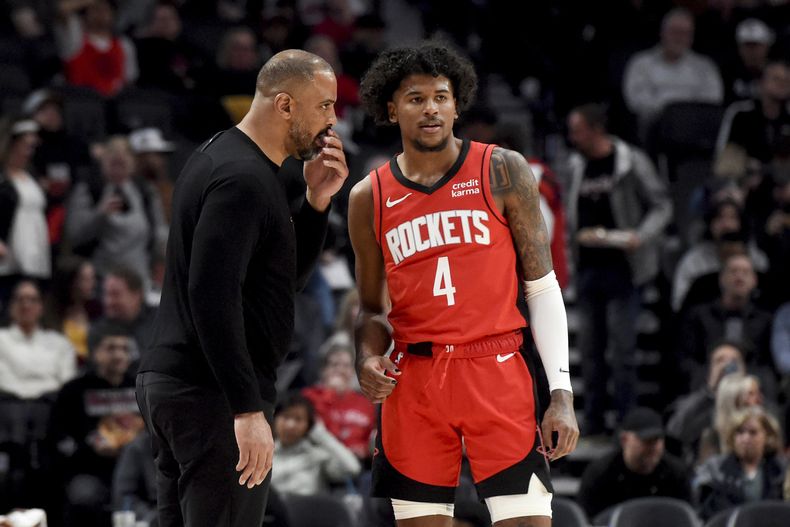El entrenador de los Rockets de Houston Ime Udoka (izquierda) conversa con el armador de los Rockets Jalen Green (4) durante la primera mitad del juego de baloncesto de la NBA ante los Trail Blazers de Portland, el viernes 8 de marzo de 2024, en Portland, Oregon. (AP Foto/Steve Dykes)