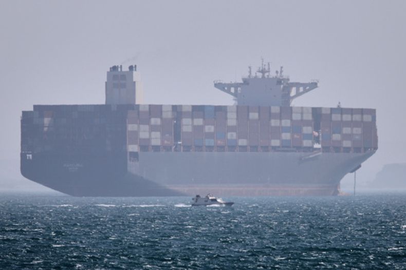 Un buque portacontenedores anclado mientras un pequeño bote de motor pasa frente a él en el estrecho de Ormuz frente a Bandar Abbas, Irán, el sábado 2 de mayo de 2026. (Amirhosein Khorgooi/ISNA vía AP)