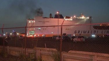 En esta imagen tomada de un video, humo saliendo de un barco de mercancías la madrugada del jueves 6 de julio de 2023 en el puerto de Newark, Nueva Jersey. Dos bomberos murieron combatiendo las llamas en el interior de un barco que transportaba 5.000 vehículos. (WABC-TV via AP)
