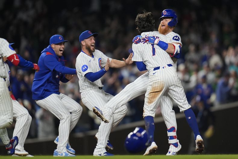 Justin Turner (derecha) es felicitado por los demás Cachorros de Chicago, tras conectar un doble que significó el triunfo sobre los Marlins de Miami, el martes 13 de mayo de 2025 (AP Foto/Erin Hooley)