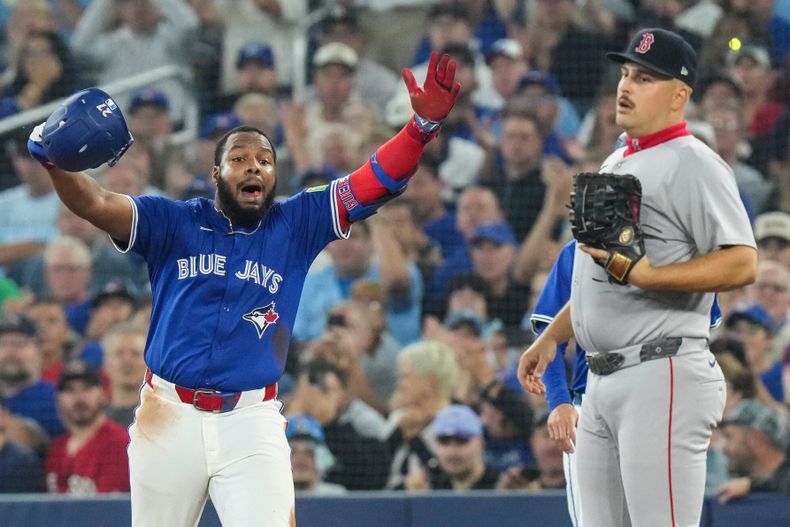 El dominicano Vladimir Guerrero, de los Azulejos de Toronto, festeja frente a Nathaniel Lowe, de los Medias Rojas de Boston, el jueves 25 de septiembre de 2025 (Chris Young/The Canadian Press via AP)