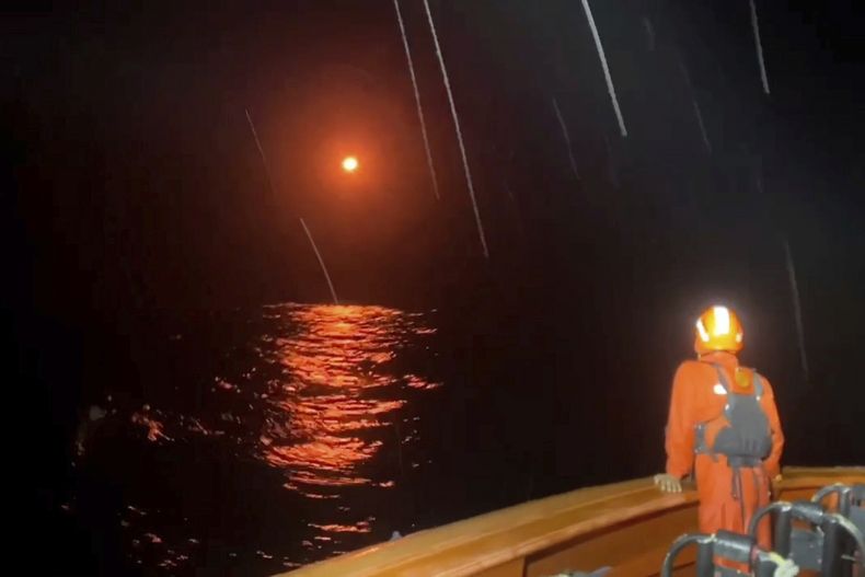 En esta imagen tomada de un video publicado por la Agencia Nacional Indonesia de Búsqueda y Rescate (BASARNAS) el martes 15 de julio de 2025, una bengala ilumina el cielo mientras los rescatistas buscan sobrevivientes del naufragio de un bote el 14 de julio, que dejó varios desaparecidos en las aguas del estrecho de Sipora en las islas Mentawai, Indonesia. (BASARNAS via AP)