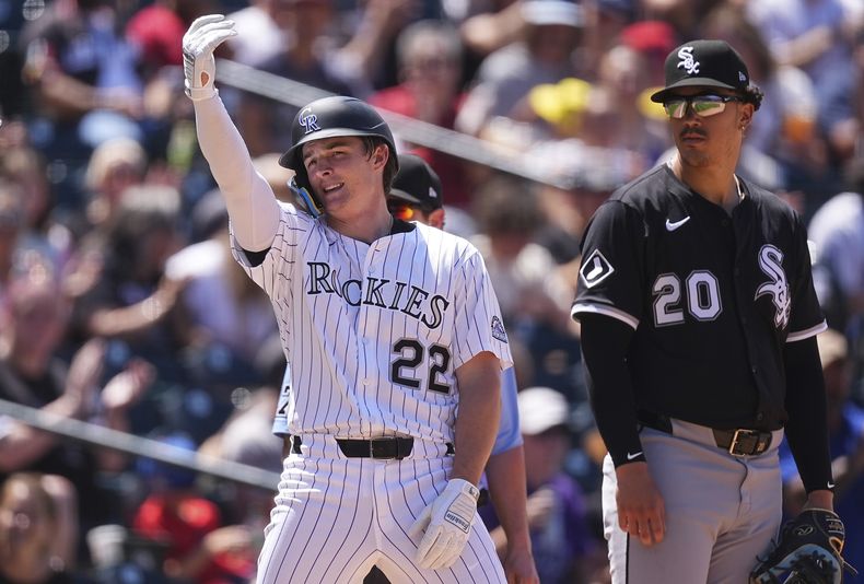 Mickey Moniak, izquierda, de los Medias Blancas de Chicago, hace señales hacia el dugout después de batear un triple y produjera dos carreras, mientras el tercera base de los Medias Blancas de Chicago, Miguel Vargas, observa en la quinta entrada del juego de béisbol de Grandes Ligas, el domingo 6 de julio de 2025, en Denver. (AP Foto/David Zalubowski)